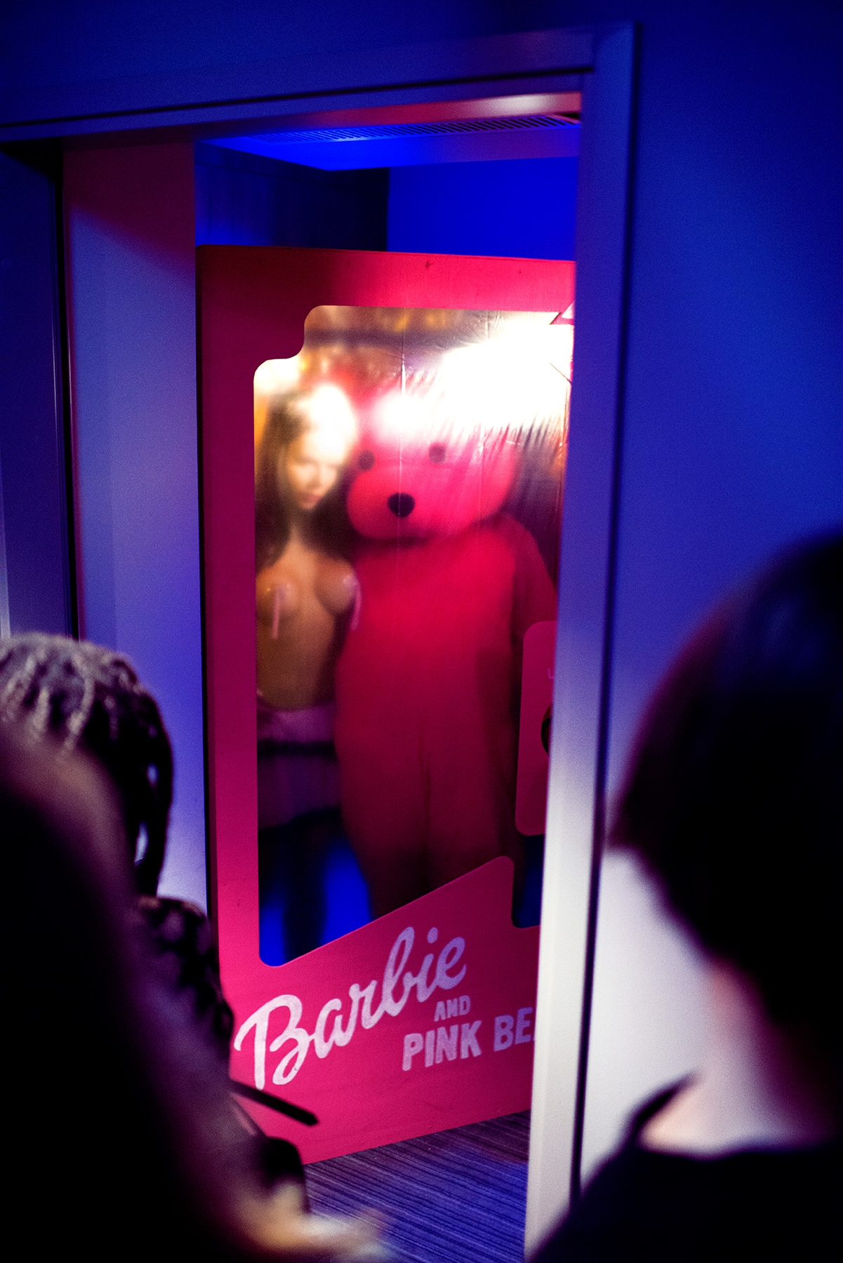 Barbie and The Pink Bear start the performance in human sized product packaging.